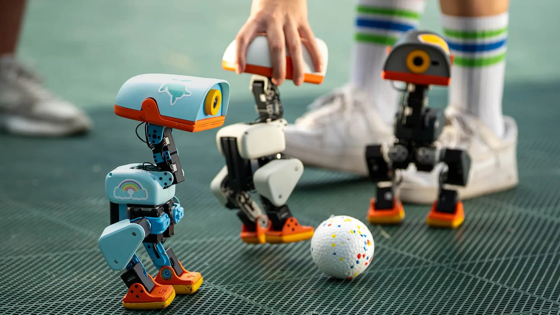Pollen Robotics 官方 Microduck 产品实拍：三台机器鸭在球场上活动
